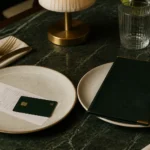 Dos platos en una mesa, uno con la cuenta del restaurante y una tarjeta, el otro con el menú cerrado.