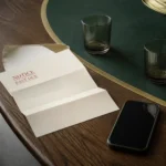 Carta de vencimiento abierta sobre la mesa del comedor, con dos vasos y un celular apagado.